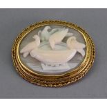 A Victorian gold mounted shell cameo brooch, carved as Pliny's doves drinking from a bowl,