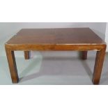 A 20th century hardwood rectangular extending dining table with one integral leaf on block supports,