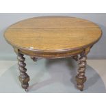 An early 20th century oak circular dining table on barley twist supports,