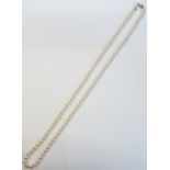 A single row necklace of uniform cultured pearls by Mikimoto,