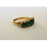 A late Victorian 18ct gold, emerald and green gem set five stone ring,