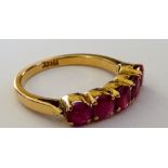 A gold and ruby five stone ring, claw set with a row of circular cut rubies,