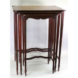 A nest of three Edwardian mahogany tables, of serpentine outline,