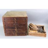 A vintage pine six drawer table top cabinet containing a large collection of wood working tools,
