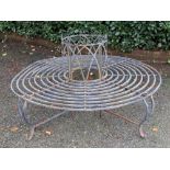 A grey wrought metal tree seat, 20th century, 144cm diameter.