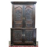 A Flemish oak cupboard, 19th century, in two parts, of raised and fielded panelled construction,