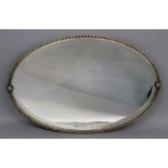 An oval bevel edge mirror in silvered metal frame, circa 1920's, 77cm wide, 51cm high.