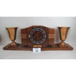 A French Art Deco walnut, chrome and copper mantel clock flanked by twin lamps, plinth base,