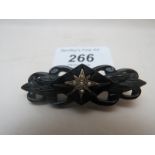 A black bar brooch with gold star design and pearls est: £20-£30