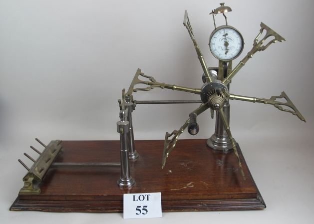 An antique brass and steel wool winder, on mahogany plinth base,70 cm wide,