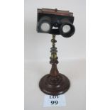 Victorian stereoscope on fine turned wood pedestal base with centre brass stand above,