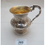 A Victorian silver christening mug with heavily embossed decoration and gilded interior London 1839