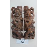 A pair of early 20th century Chinese carved wooden figures, candle holders or lamp bases,