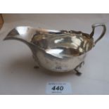 A silver sauce boat on pad feet,