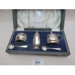 A boxed silver condiment set comprising of salt,