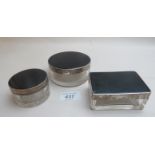 A collection of three glass jars with black enamel and silver tops,
