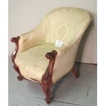A Victorian rosewood framed tub chair upholstered in traditional cream material and terminating on