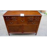 A 20th century mahogany sideboard with a large central square drawer flanked either side by five
