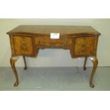 A c1920 Queen Anne design walnut desk with a centre drawer flanked either side by two deep drawers