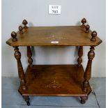 A small Victorian walnut inlaid two tier side table with turned supports and finial's,