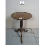 A small late 19th century tripod wine table on a barley twist column and terminating on pad feet