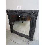 A 20th century black carved and moulded wall mirror with bevelled mirror glass est: £40-£60