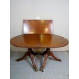A 20th century Regency design twin pedestal mahogany dining table complete with one additional leaf