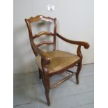 A 19th century oak framed armchair with rush seat over barley-twist support and shaped legs est: