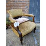 A 19c mahogany framed tub chair upholstered in gilt floral material and with a carved back splat