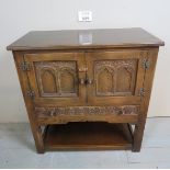 A 20th century carved oak cabinet / sideboard of small proportions with double carved doors over a