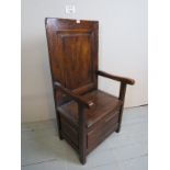 A 20th century oak single monk's bench/seat with a high panelled back over a lift up seat with