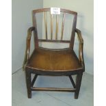 A 19th century oak elbow chair of small proportions and with solid planked seat and lower stretcher