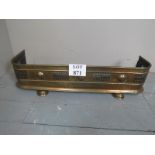 A small decorative brass fire fender wit