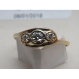 A gold three stone diamond ring (size V)