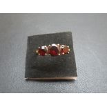 A 9ct gold three graduated garnet set ri