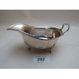 A silver sauce boat with double scroll h