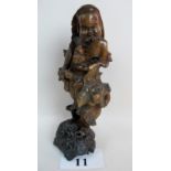 An antique Chinese root carving depicting a bearded male figure carrying a bottle, scrolled base,