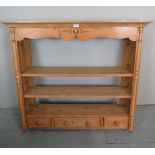 A 19th century solid pine wall hanging plate rack with three shelves over two small and one long