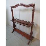 A pretty 19th century mahogany freestanding boot rack with carved end supports and turned pegs est: