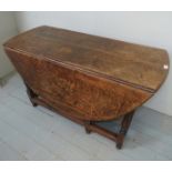 An 18th century solid oak oval gateleg dining table, with turned legs and supports,