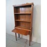 An Edwardian oak bookcase on stand of slim proportions with three shelves to top,