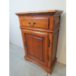 A 20th century oak slim line cupboard with a single drawer to top,