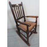 A small oak rush seated rocking chair in need of some attention est: £15-£20