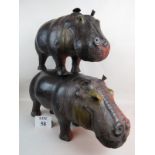 Two graduated leather finished models of hippos,