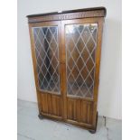 A 20th century oak old charm bookcase/cabinet, with double glazed doors,