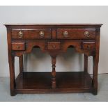 A small period style oak dresser base, with two long drawers, over three small and a lower shelf.