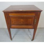 An Edwardian inlaid mahogany side cabinet with interior shelves and terminating on tapered legs, 31.