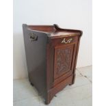 A decorative 19th century mahogany coal-box, with a carved panelled door and brass side handles,