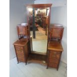 A late 19th/early 20th century walnut bedroom dressing cabinet, with a central cheval mirror,