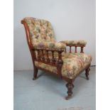 A mahogany framed Victorian gentleman's fireside armchair, with turned spindle arm rest supports,